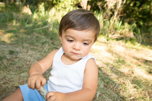 Niño feliz jugando en el parque de césped del jardín de verano