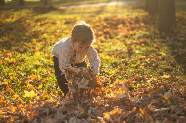 Niño feliz jugando en el parque otoño