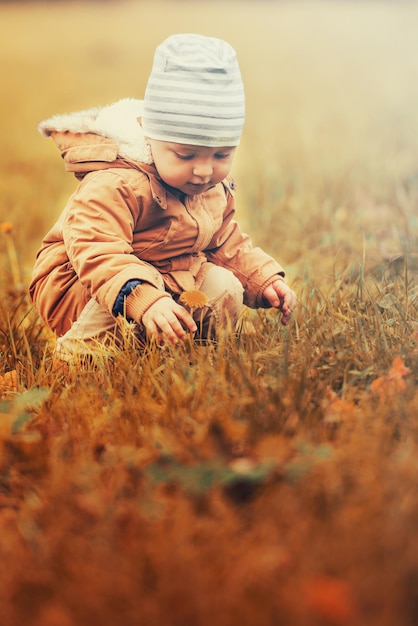 Niño feliz jugando en el parque de otoño