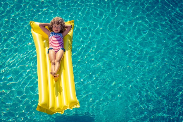 Niño feliz jugando en la piscina retrato de vista superior