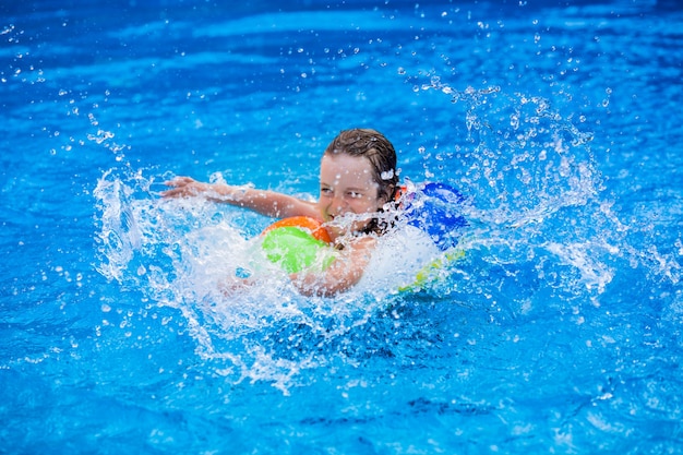 Niño feliz jugando en la piscina