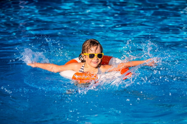 Niño feliz jugando en la piscina