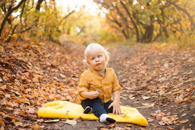 Niño feliz jugando y riendo en la caminata de otoño