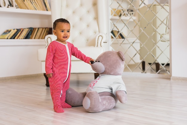 Niño feliz jugando con su osito de peluche.