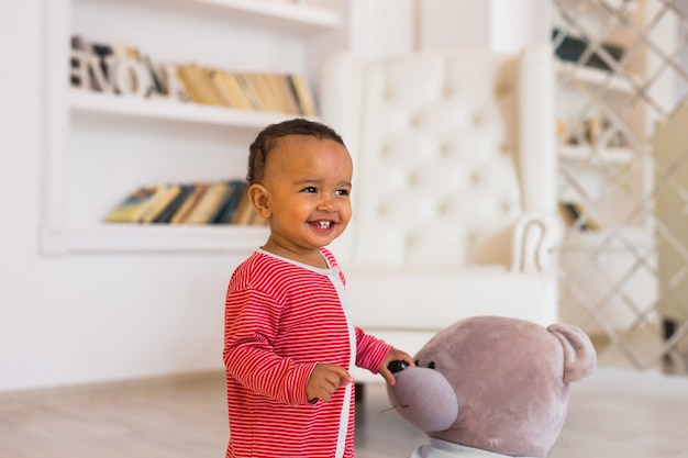 Niño feliz jugando con su osito de peluche.