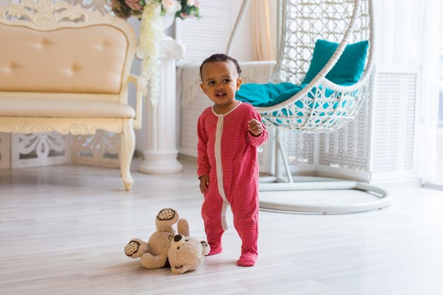 Niño feliz jugando con su osito de peluche.