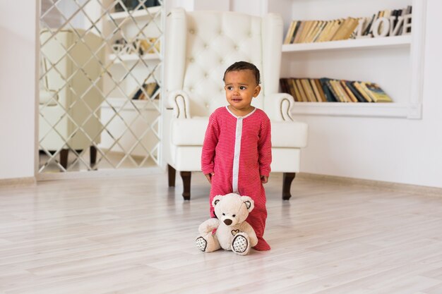 Niño feliz jugando con su osito de peluche.