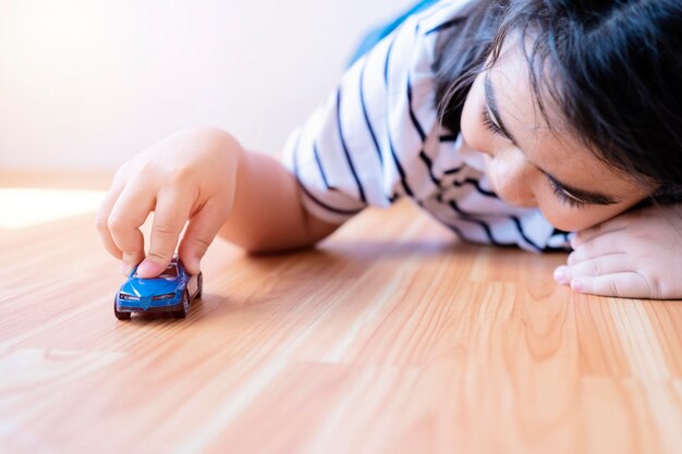 Niño feliz jugando con un viejo juguete de automóvil en casa Un niño asiático juega un modelo de automóvil que tiene fantasías y sueños