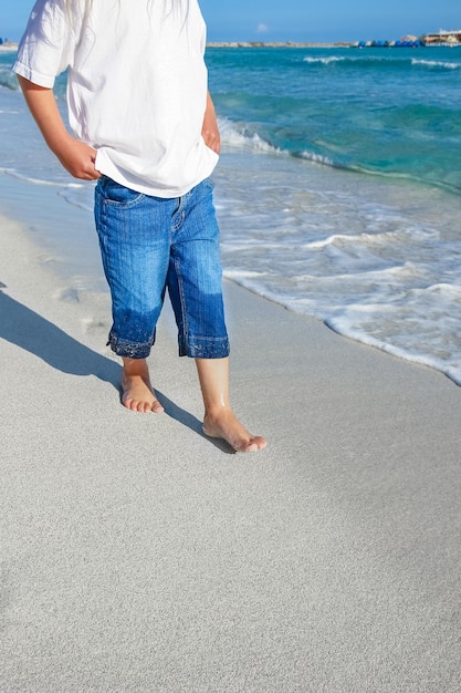 Niño feliz junto al mar al aire libre.