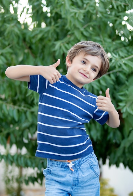 Niño feliz con largo cabello rubio y diciendo OK