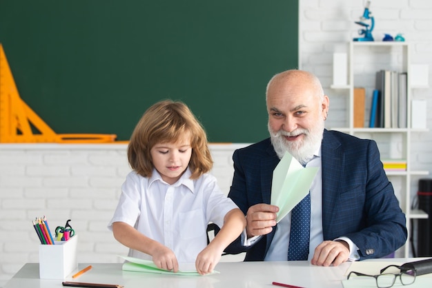 Niño feliz en maestro de escuela con alumno con aviones educación enseñanza escuela primaria