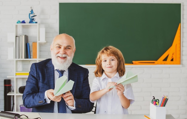 Niño feliz en el maestro de la escuela ayuda a aprender la enseñanza de la educación en la escuela primaria