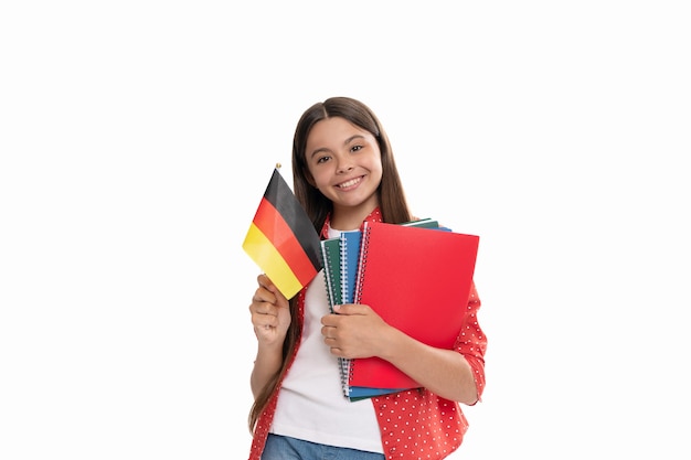 Niño feliz mantenga la bandera alemana y el cuaderno escolar para estudiar aislado en blanco, idioma extranjero.