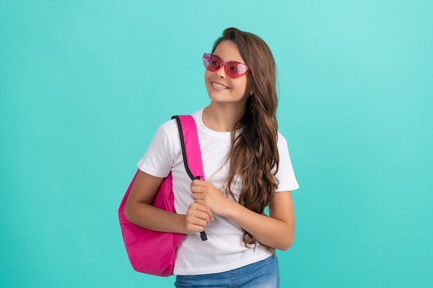 Niño feliz con mochila y cuaderno en gafas de sol listo para estudiar en la escuela, regreso a la escuela
