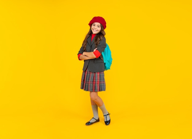 Niño feliz con mochila escolar. jovencita en boina llevar mochila. De vuelta a la escuela.