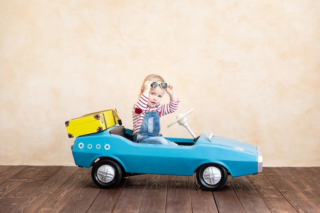 Foto niño feliz montando coches de época de juguete
