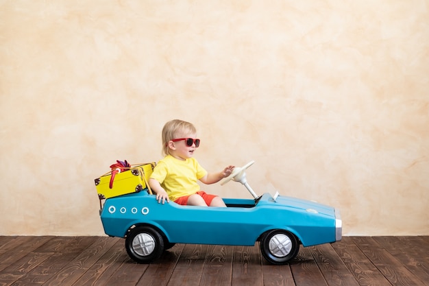 Foto niño feliz montando coches de época de juguete