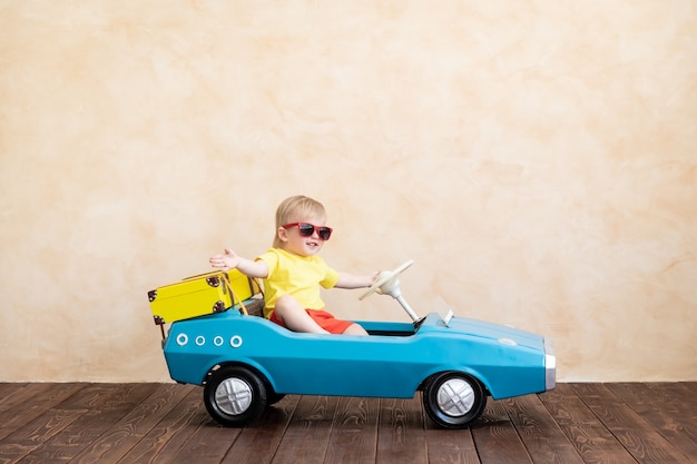 Foto niño feliz montando coches de época de juguete