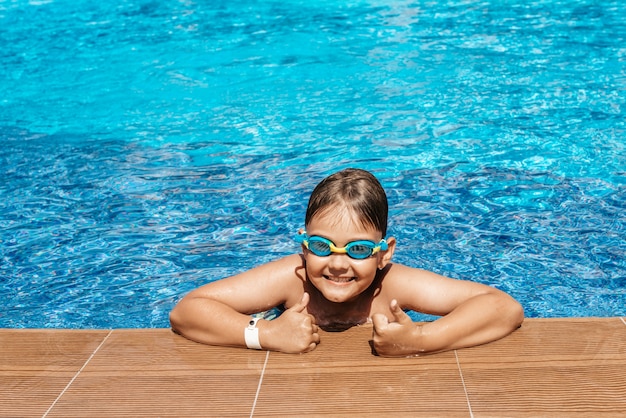 Niño feliz nadando en la piscina