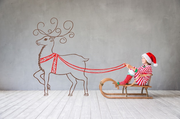 Niño feliz en Navidad. Niño gracioso jugando en casa