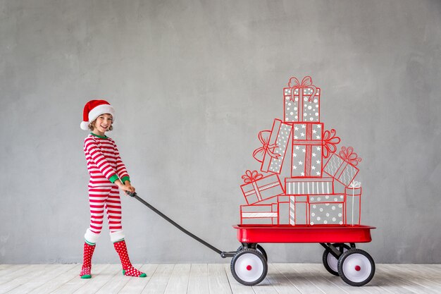 Niño feliz en Navidad. Niño gracioso jugando en casa