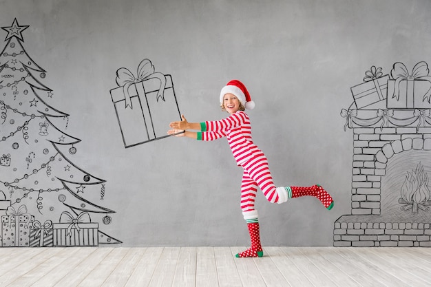 Niño feliz en Navidad. Niño gracioso jugando en casa