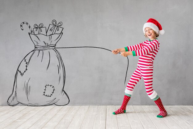 Niño feliz en Navidad. Niño gracioso jugando en casa