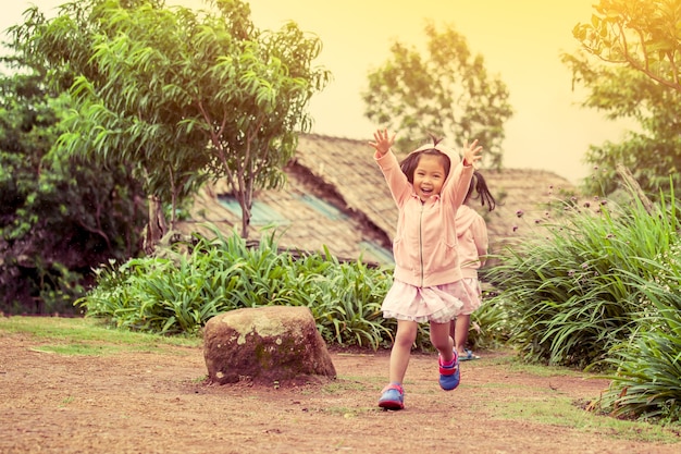 Niño feliz niña corriendo y divirtiéndose en el jardín