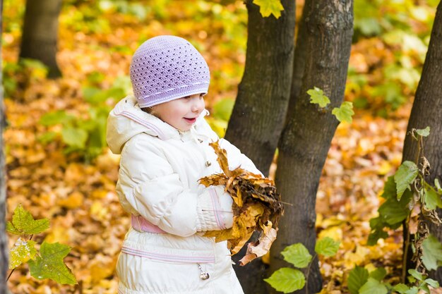 Foto niño feliz, niña riendo y jugando en el otoño en la naturaleza caminar al aire libre