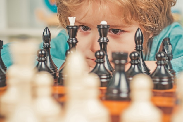 Niño feliz y niñez inteligente niño pensando en ajedrez lindo niño jugando al ajedrez
