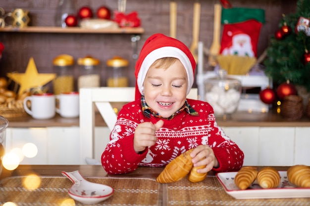 niño feliz niño celebrar la navidad en la cocina de casa feliz navidad y próspero año nuevo