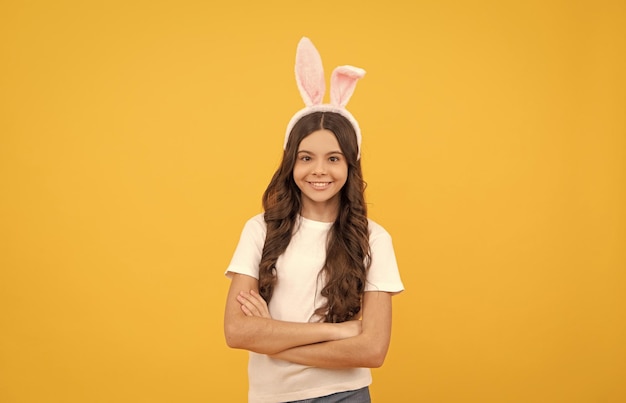 Niño feliz en orejas de conejo sobre fondo amarillo pascua