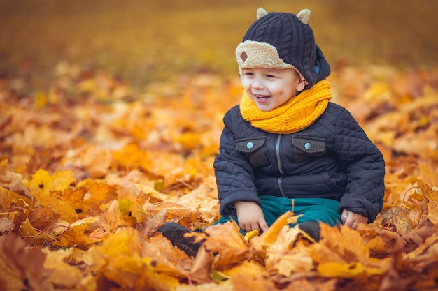 Niño feliz en el parque otoño