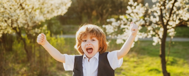 Niño feliz en el patio trasero de la escuela jardín floreciente niño de primavera en el parque