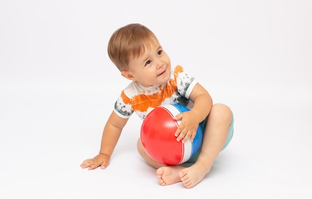 Niño feliz con una pelota aislada en blanco