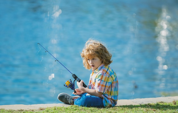 Niño feliz pescando en el lago chico con spinner en concepto de pesca de río