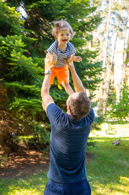 Foto niño feliz de pie en el árbol contra las plantas