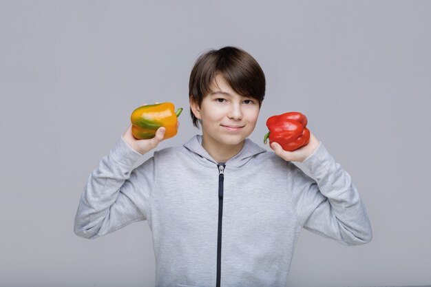 Niño feliz con pimiento dulce, alimentación saludable y concepto de estilo de vida