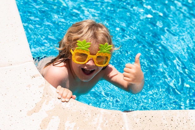 Niño feliz en la piscina el día de verano Juego de niños en un resort tropical Vacaciones de verano