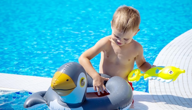 Niño feliz en la piscina jugando con una pistola de agua.