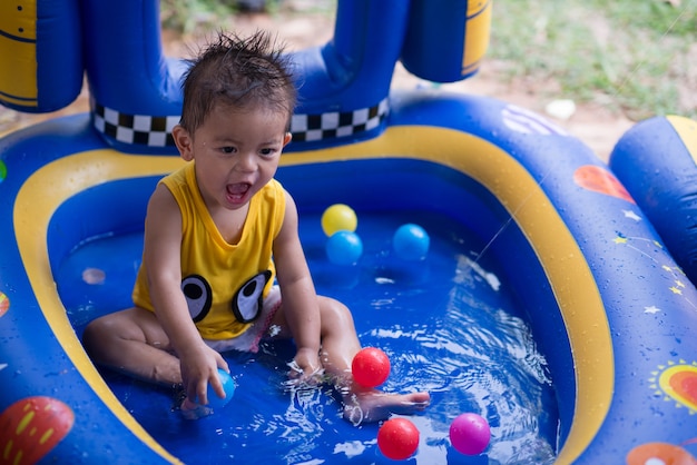 Niño feliz con piscina para niños