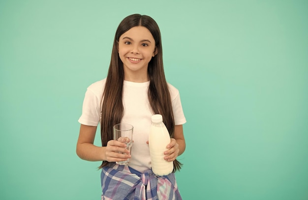 Niño feliz que va a beber un vaso de leche o un producto diario de yogur