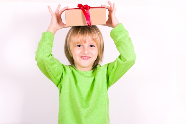 Niño feliz con regalo de Navidad en la mano. Concepto para navidad