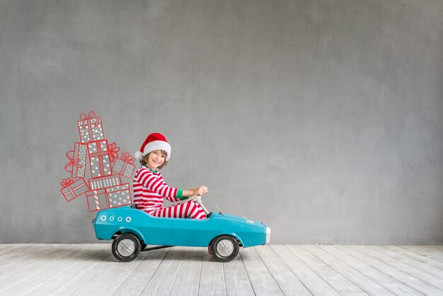 Niño feliz con regalo de Navidad. Niño divirtiéndose en casa