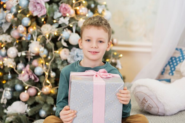 Niño feliz con regalo de Navidad. niño encantado con regalo.