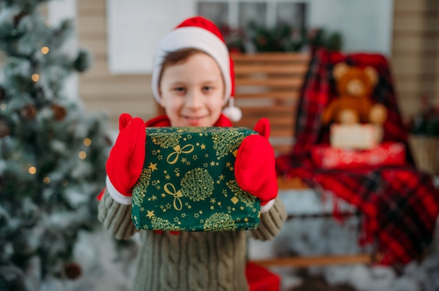 Niño feliz con regalos en decoraciones de navidad