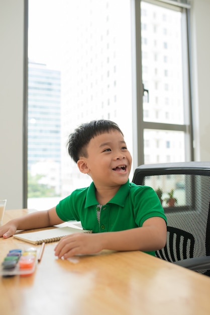 Niño feliz riendo mientras estudia