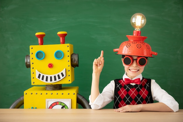 Niño feliz con robot de juguete en la escuela