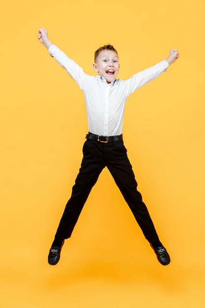 Niño feliz saltando de alegría. La felicidad, la actividad y el concepto de niño.