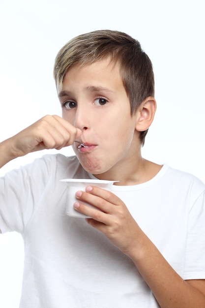 Niño feliz sano comiendo yogur